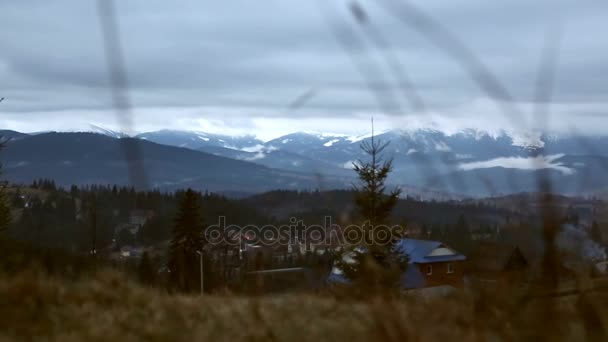 Spring in the mountains, partly snow. Snow, clouds and mountains. Evening clouds cover buildings - Footage, Video