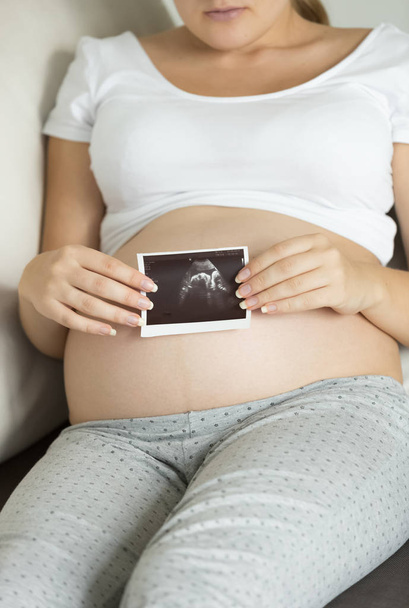 Крупним планом фото вагітної жінки, що тримає ультразвукове сканування
 - Фото, зображення