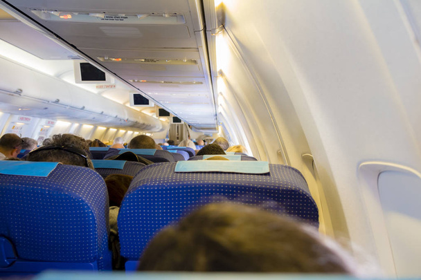 Interior of passenger airplane with people on seats - Valokuva, kuva