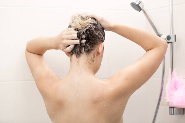 Sexy femme brune laver les cheveux avec shampooing à la douche
 - Photo, image