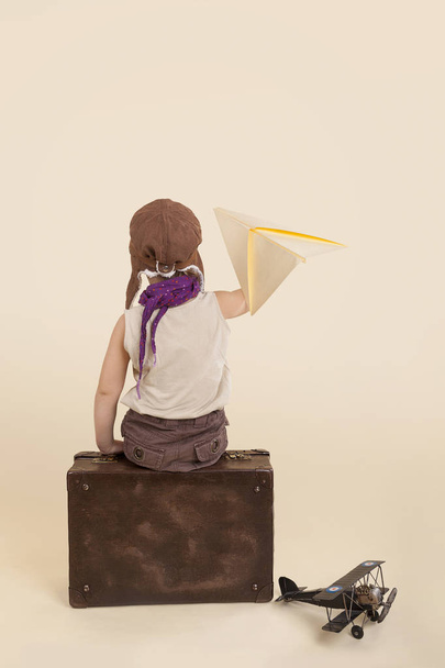 Kind hält Papierflugzeug in der Hand. - Foto, Bild