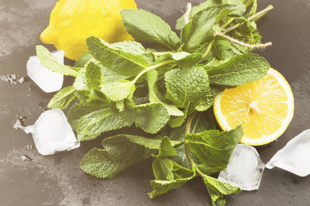 Ingredienti per limonata - limone, ghiaccio, zecca su uno sfondo scuro. Tonificante
 - Foto, immagini