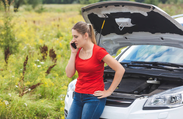 Woman leaning on broken car and calling for help by mobile phone - Fotoğraf, Görsel