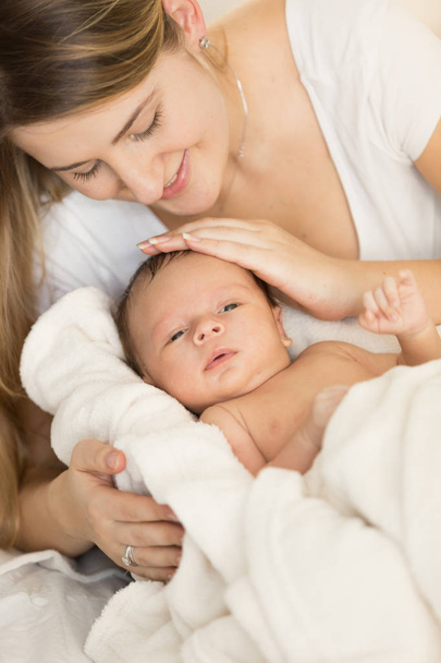 Genç bakan anne yeni doğan bebek üzerinde sarılma closeup portresi  - Fotoğraf, Görsel