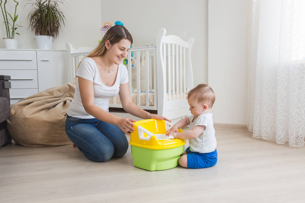 Loving mother teaching her baby boy how to use chamber pot - Photo, Image