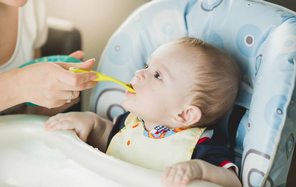 Portrait of baby boy eating puree from spoon - Photo, Image