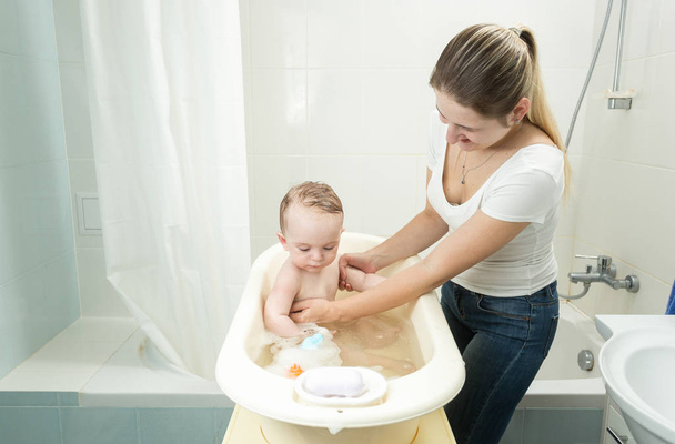 Mother washing her baby son in bath - Foto, Imagem
