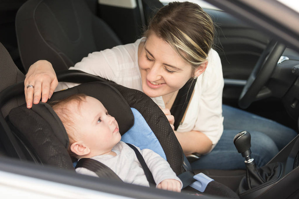 Χαμογελώντας η μητέρα έχοντας το αγόρι μωρό κάθισμα ασφαλείας αυτοκινήτου - Φωτογραφία, εικόνα
