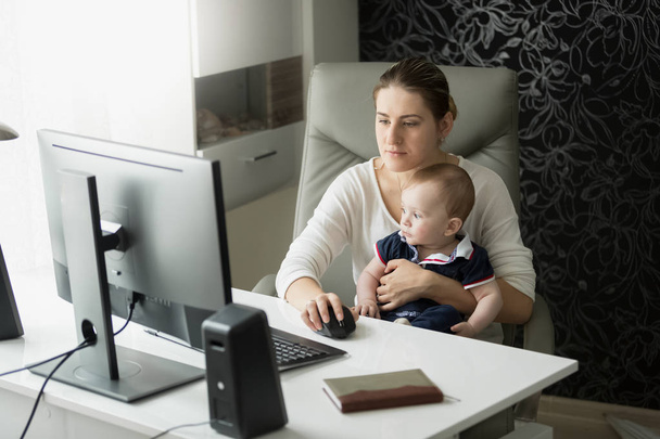 Young mother working at home office and taking care of her baby  - Photo, Image
