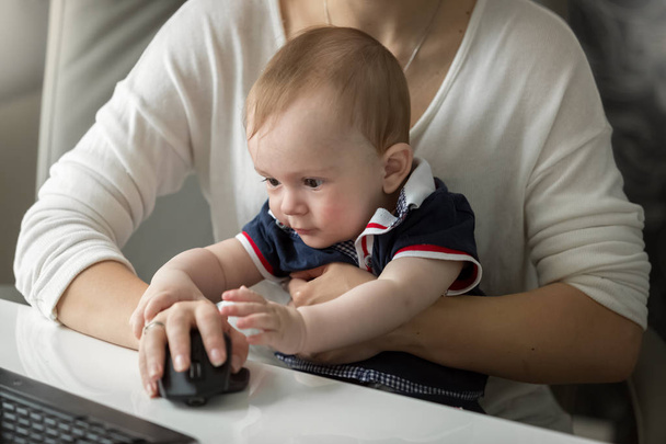 Woman working at home office and taking care of her baby son - Photo, Image