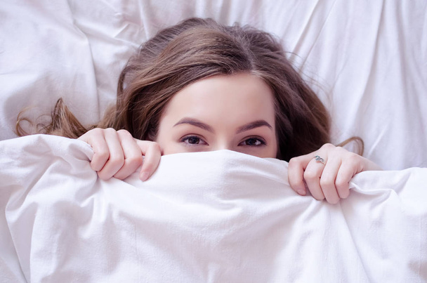 Krásná mladá žena vleže v posteli - Fotografie, Obrázek