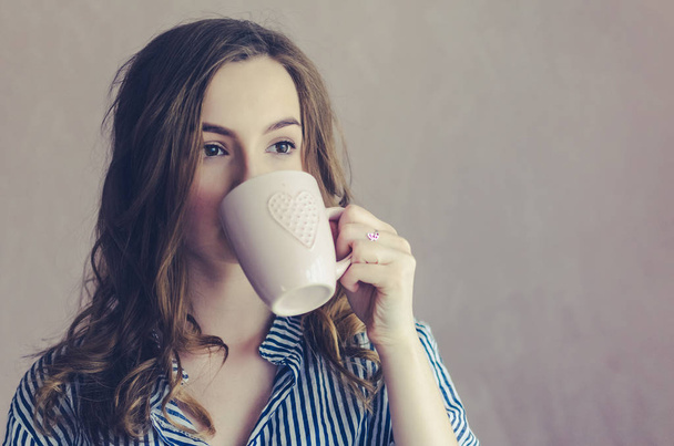Młoda dziewczyna picia kawy lub herbaty rano - Zdjęcie, obraz