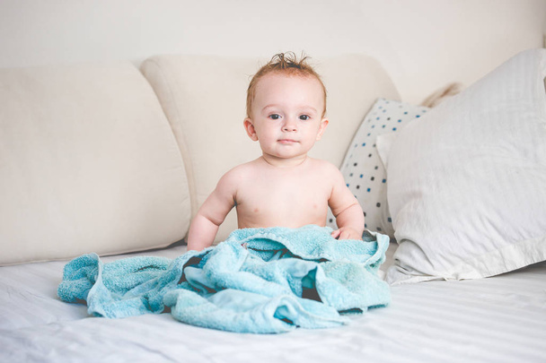 Feliz bebê de 9 meses de idade na cama após o banho
 - Foto, Imagem