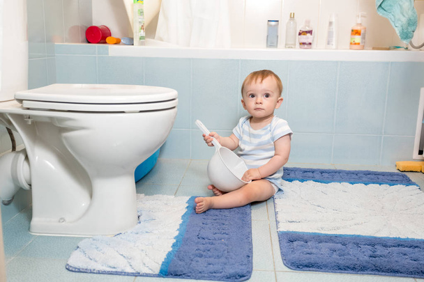 Чарівний хлопчик сидить на підлозі у ванній
 - Фото, зображення
