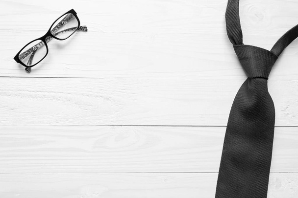 Zwart-wit beeld van mannelijke stropdas en brillen liggend op wh - Foto, afbeelding