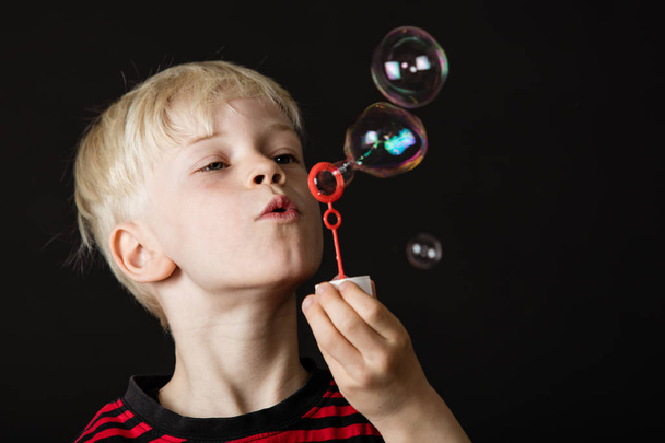 Attractive little blond boy blowing bubbles - Zdjęcie, obraz