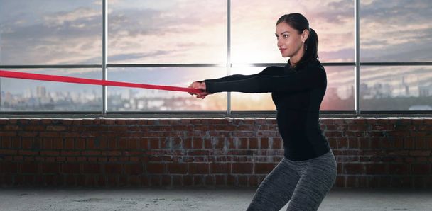 Athlète femme faisant de l'exercice avec du caoutchouc sportif dans la salle de gym
 - Photo, image