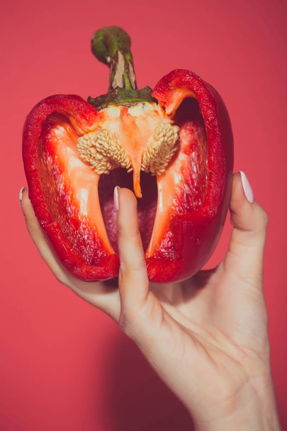 half of bell pepper in hand of woman, heart - Φωτογραφία, εικόνα
