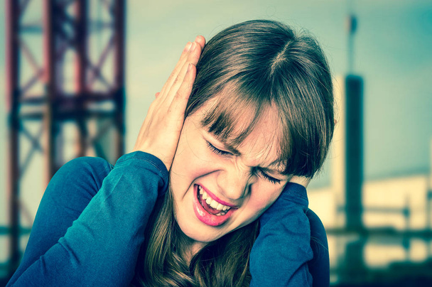 Woman covering her ears to protect from loud noise - Photo, Image