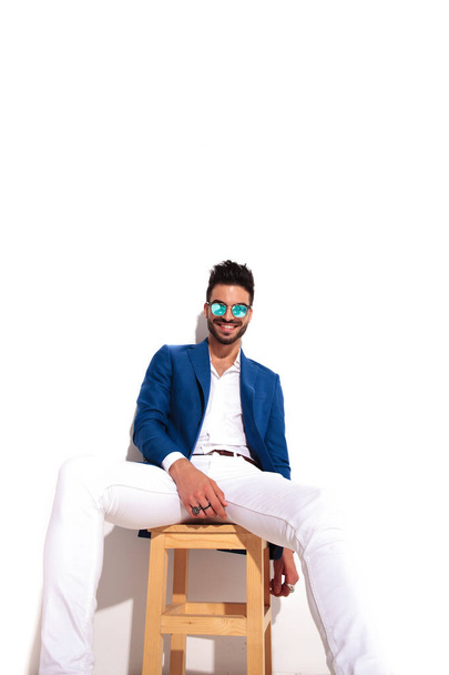модный элегантный мужчина смеется, сидя на стуле
 - Фото, изображение