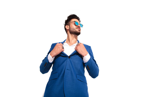 elegant man in sunglasses pulling his collar like superman - Фото, изображение