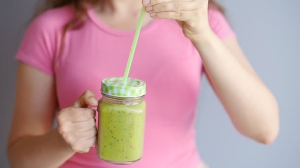 Μια ευτυχισμένη γυναίκα ένα πράσινο smoothie κρατά στα χέρια της - Πλάνα, βίντεο