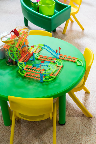 Juguete ferroviario de color plástico en mesa redonda verde
 - Foto, Imagen
