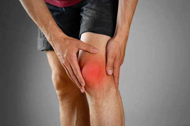 The guy clings to a bad knee. The pain in his leg. Closeup. The  - Foto, Imagen