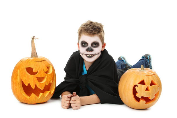 chłopiec w kostium halloween, leżącego w pobliżu dynie - Zdjęcie, obraz