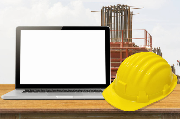 Yellow safety helmet and laptop  - Photo, Image