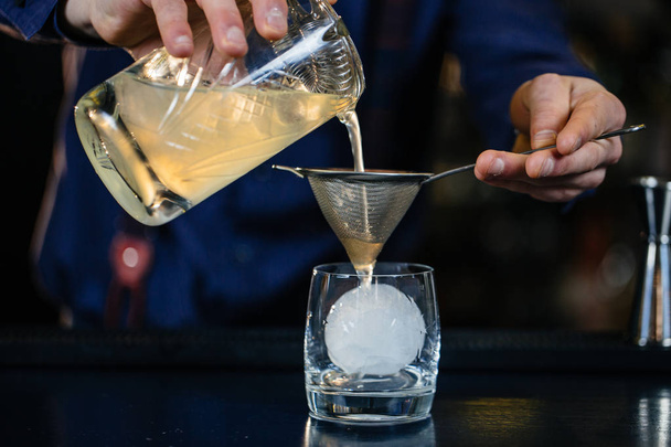 Bartender is making cocktail at bar. - Фото, изображение