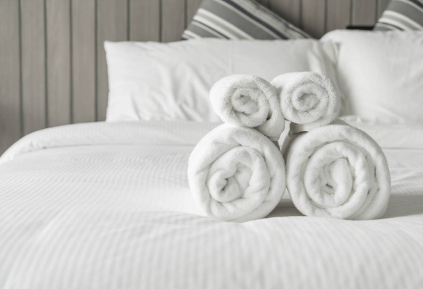 Asciugamano bianco sulla decorazione del letto in camera da letto interno
  - Foto, immagini