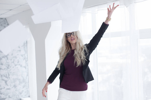 Young businesswoman throws paper document pages in office. - Foto, Bild