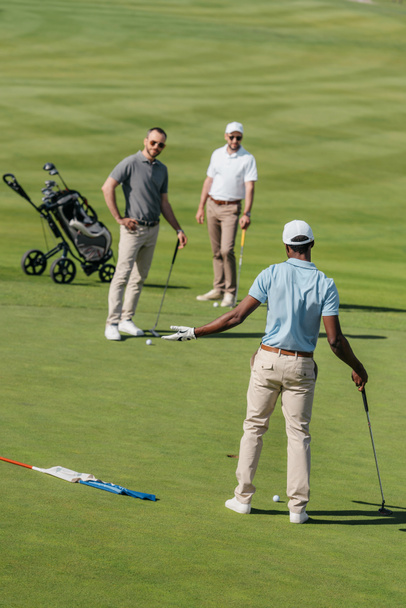 monikansalliset golfaajat puhuvat pelin aikana
 - Valokuva, kuva