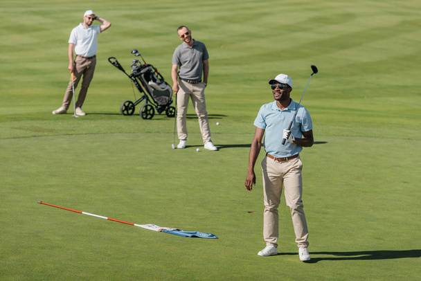sportifs debout avec des clubs de golf sur le terrain
 - Photo, image