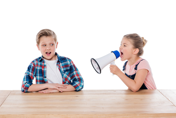 girl with megaphone yelling on her brother - Zdjęcie, obraz