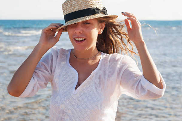 Una giovane donna con un cappello di paglia, che ride fervidamente contro il bac
 - Foto, immagini
