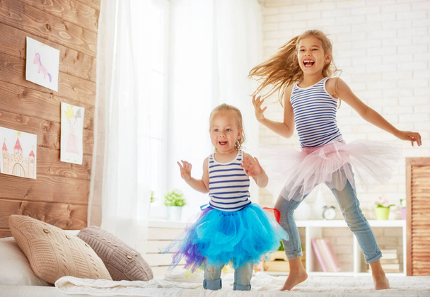 sisters jumping on the bed - Fotografie, Obrázek