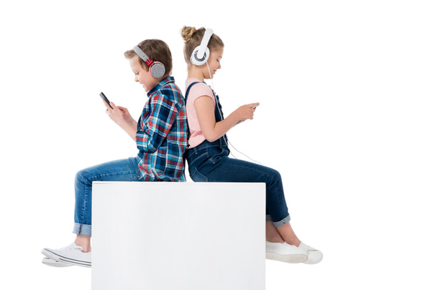 children using smartphones in headphones - 写真・画像