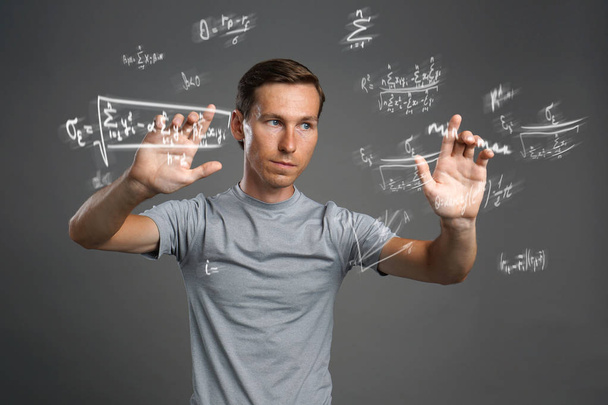 Man scientist or student working with various high school maths and science formulas. - Photo, Image