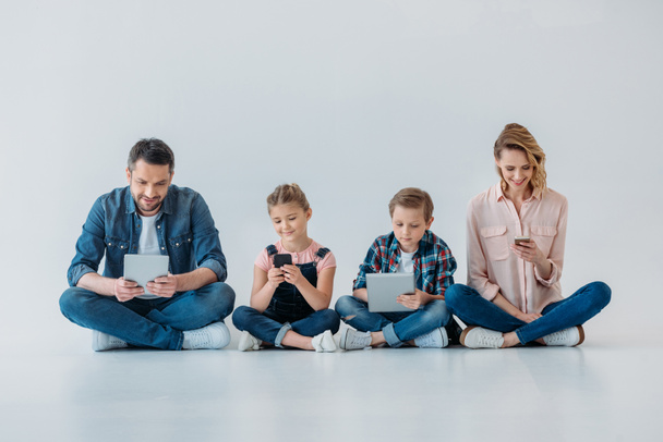 familia feliz utilizando dispositivos digitales
 - Foto, Imagen