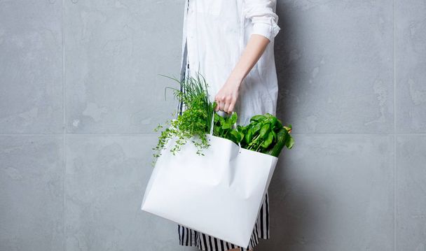 woman holding white bag with herbs - Fotoğraf, Görsel