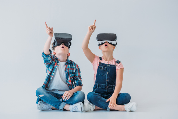 kinderen met behulp van virtuele realiteit headsets - Foto, afbeelding