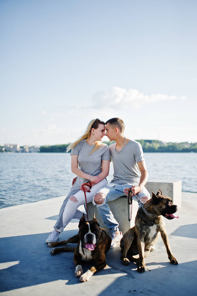 Couple in love with two dogs pit bull terrier against beach side - Foto, Bild