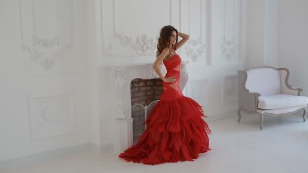 Прекрасная женщина в красном платье позирует в студии
. - Кадры, видео