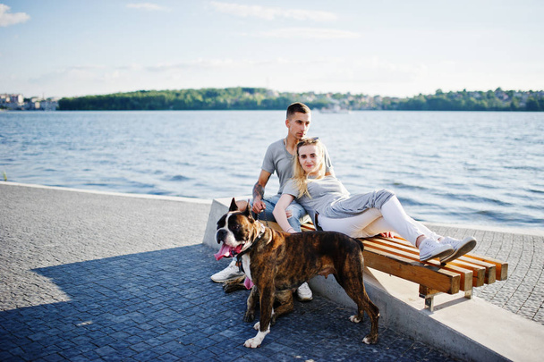Couple in love with two dogs pit bull terrier against beach side - Foto, imagen