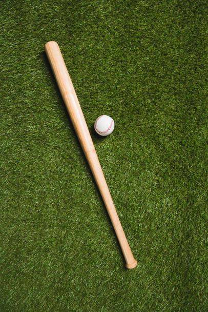 Honkbalknuppel en bal op gras - Foto, afbeelding