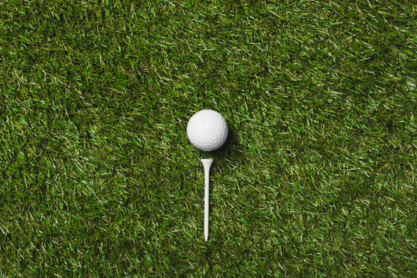 golf ball and tee on grass - Foto, afbeelding