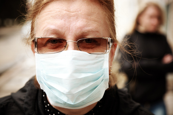 mujer protegiéndose contra la gripe con una máscara facial
 - Foto, Imagen