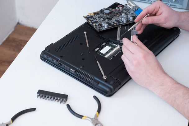 Professionele man repareren en monteren van laptop - Foto, afbeelding